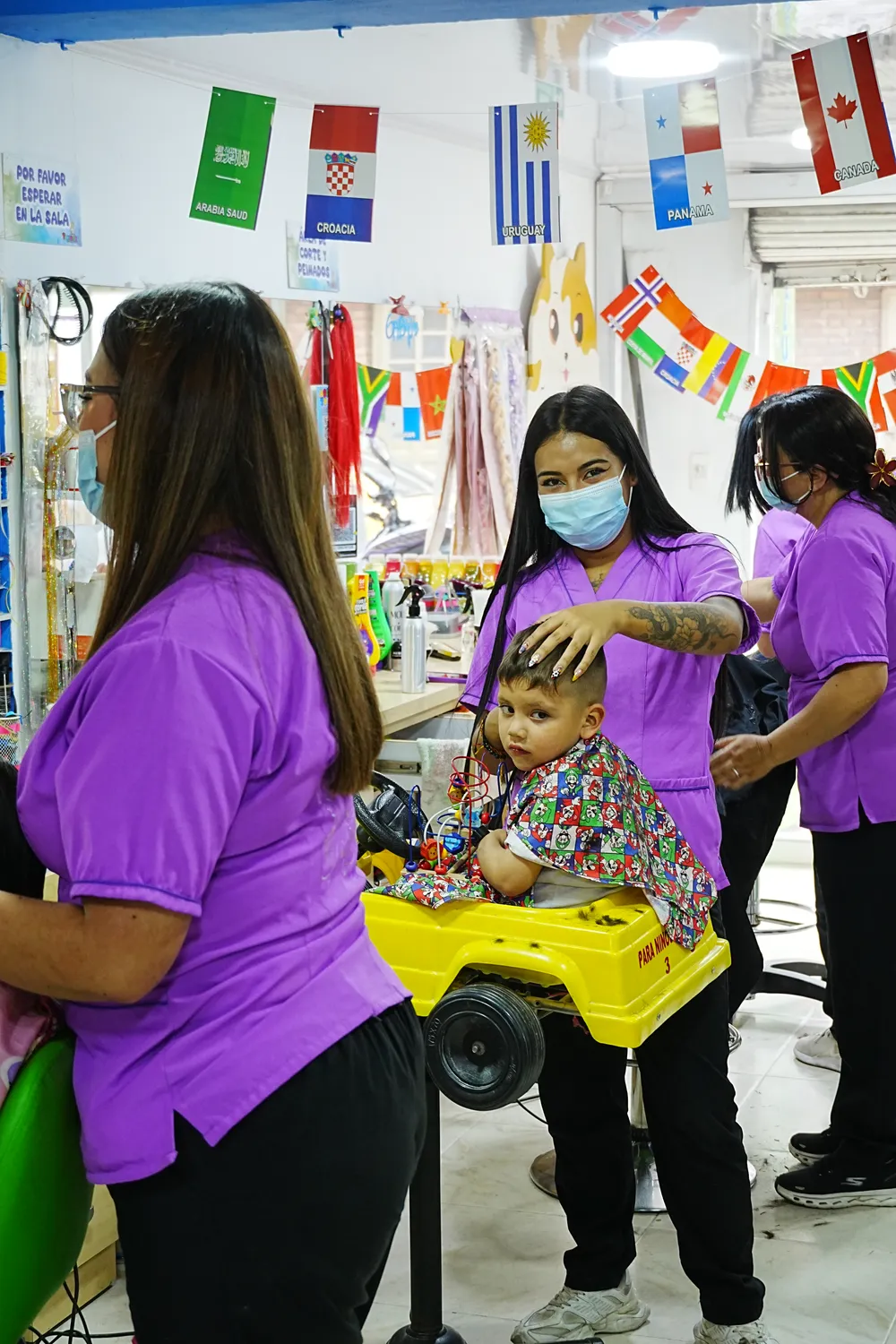 Estilista de Tinkerbell sonriendo con un niño en el salón