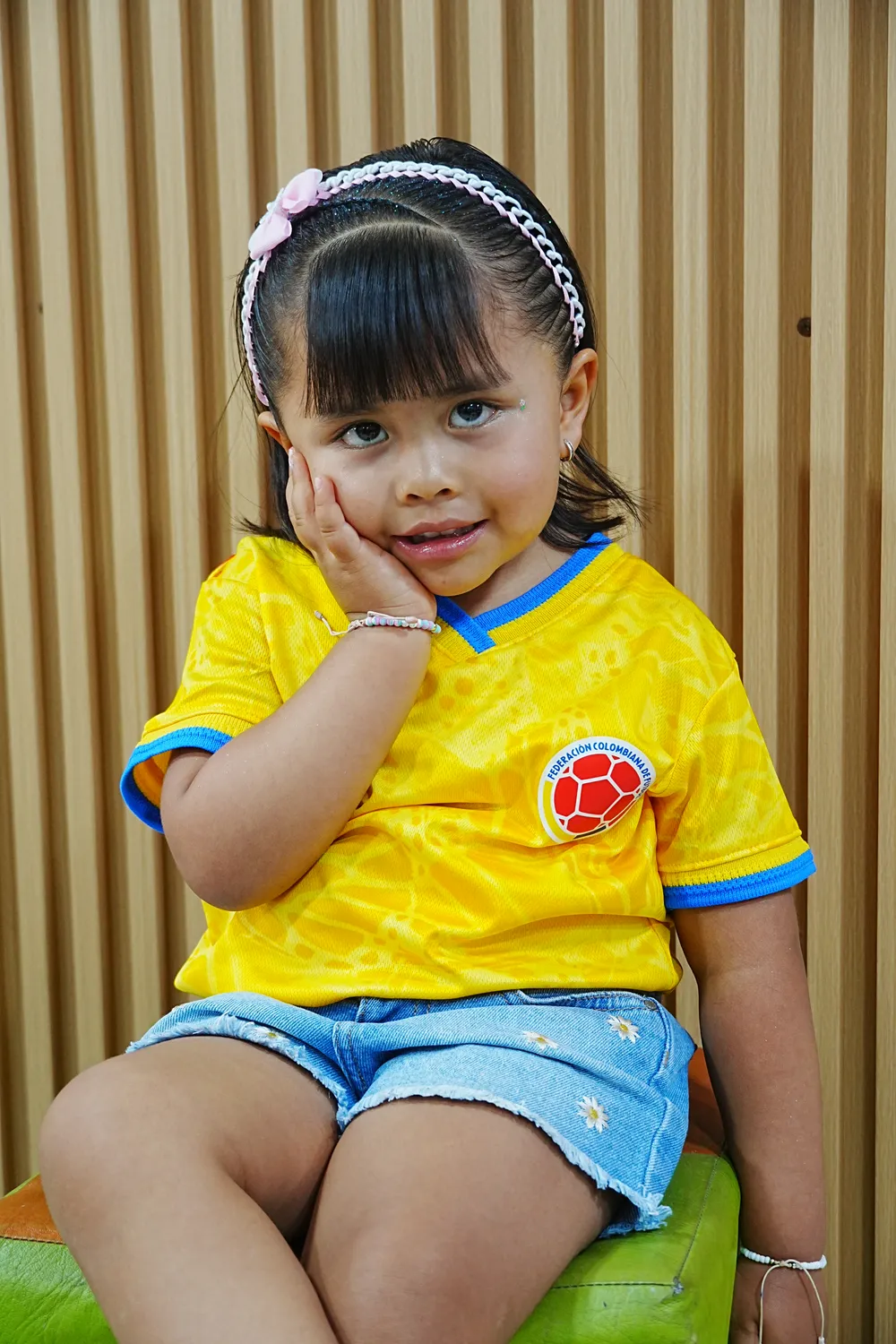 Niña con camiseta de Colombia posando en el salón