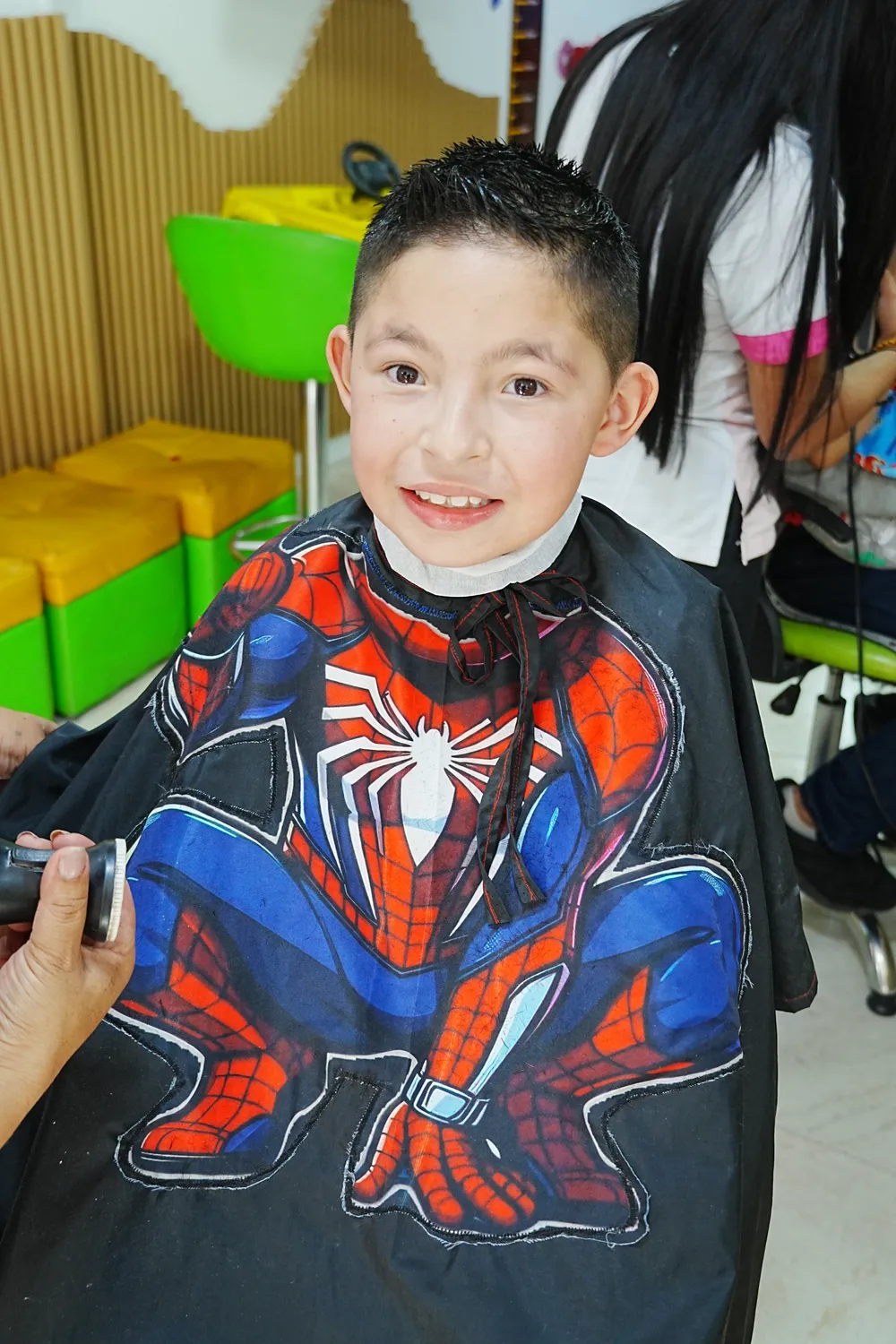 Niño feliz con capa de superhéroe en su corte